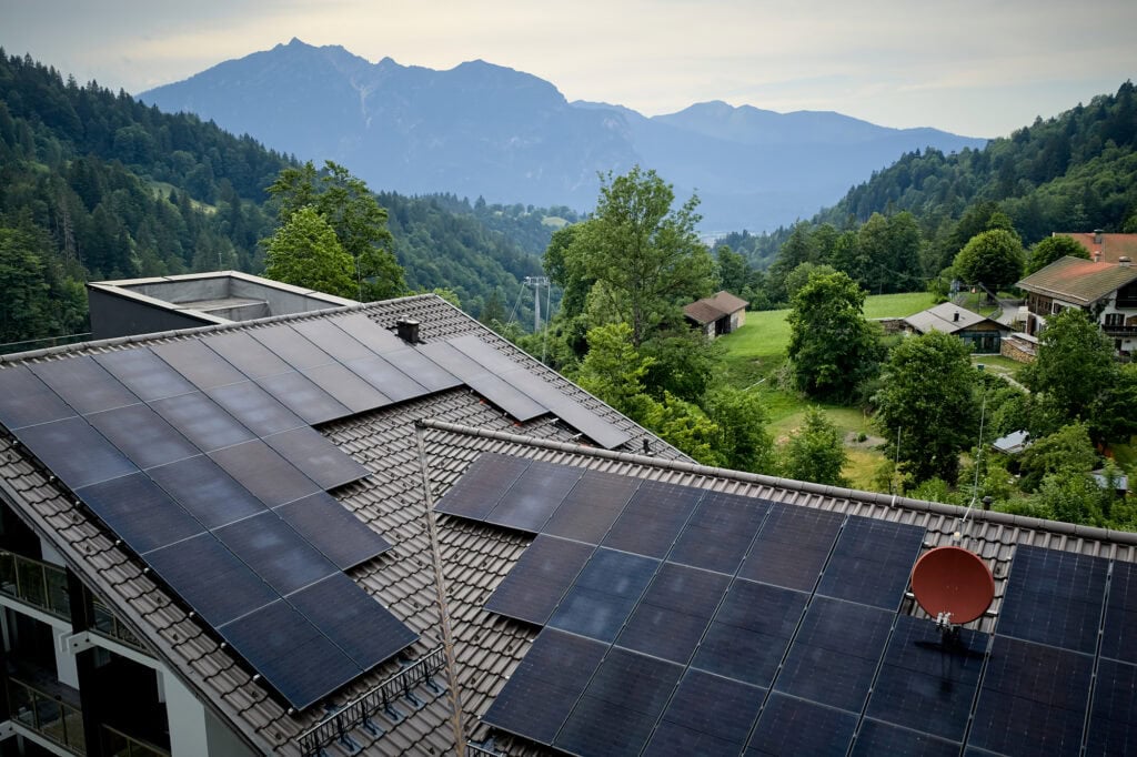 Solarpaneele auf Dach in sonniger Berglandschaft.